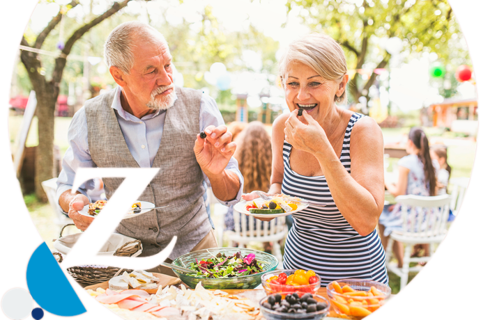 pareja mayor divertida comiendo al aire libre