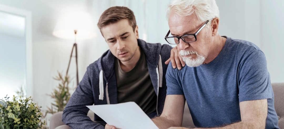 Dos hombres revisando un documento concentrados y con cara de preocupación