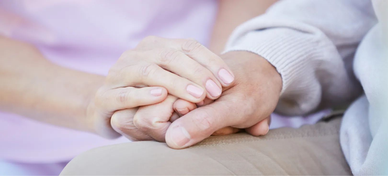 Mano de una persona sujetando con ternura la de un adulto mayor