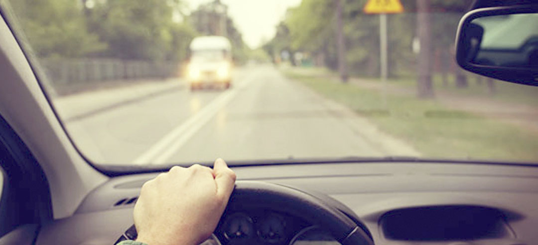 Persona conduciendo un coche por la carretera